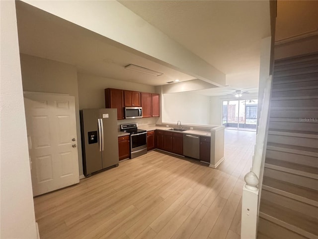 kitchen featuring appliances with stainless steel finishes, light wood-type flooring, ceiling fan, and sink