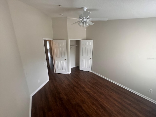 unfurnished bedroom featuring ceiling fan, dark wood-type flooring, high vaulted ceiling, and a closet