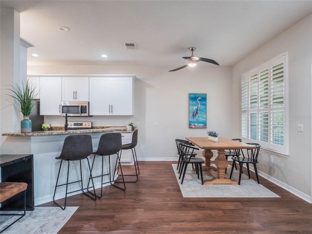 dining room featuring dark hardwood / wood-style flooring and ceiling fan