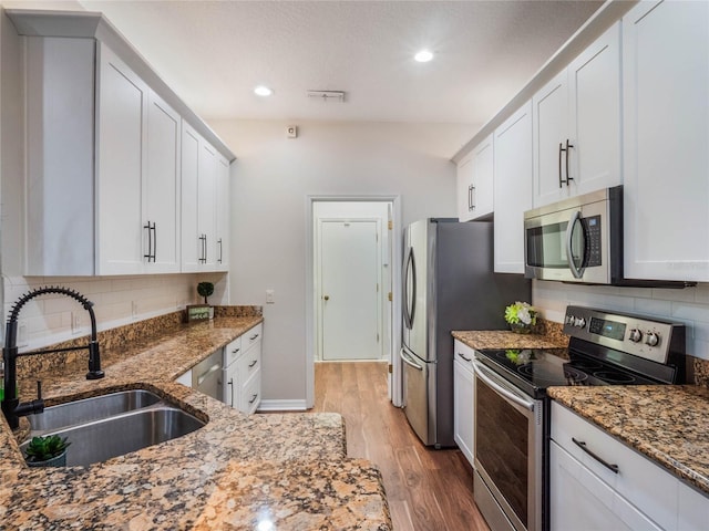 kitchen featuring white cabinetry, sink, stainless steel appliances, and light hardwood / wood-style flooring