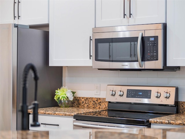 room details with white cabinets, stainless steel appliances, tasteful backsplash, and stone counters