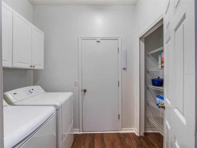 laundry area with washing machine and clothes dryer, dark wood-type flooring, and cabinets