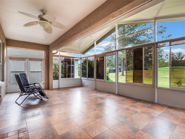 unfurnished sunroom featuring a wealth of natural light, ceiling fan, and lofted ceiling with beams