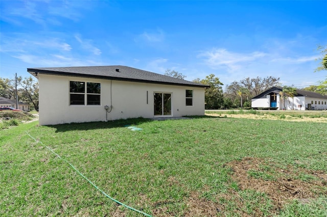 205 E 17th St, Apopka, FL 32703 - rear view of property featuring stucco siding and a lawn