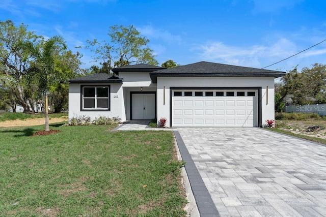 205 E 17th St, Apopka, FL 32703 - prairie-style home featuring stucco siding, decorative driveway, a garage, and a front yard