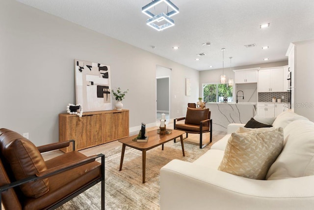 205 E 17th St, Apopka, FL 32703 - living room featuring light wood-style floors, baseboards, and recessed lighting