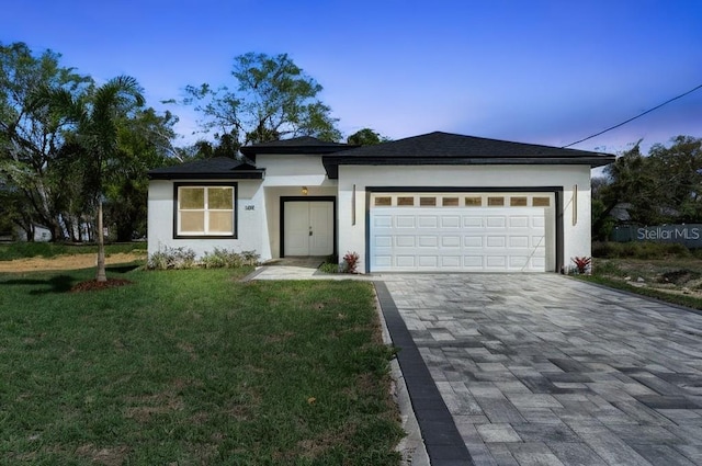 205 E 17th St, Apopka, FL 32703 - view of front of home with decorative driveway, a yard, an attached garage, and stucco siding