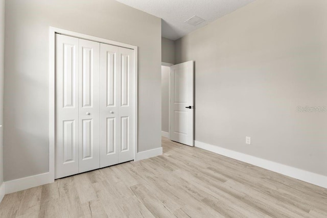 205 E 17th St, Apopka, FL 32703 - unfurnished bedroom featuring light wood-style flooring, baseboards, and a closet