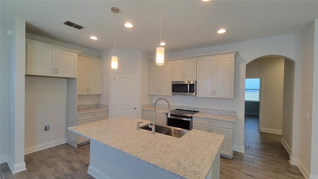 kitchen featuring hanging light fixtures, sink, an island with sink, and appliances with stainless steel finishes