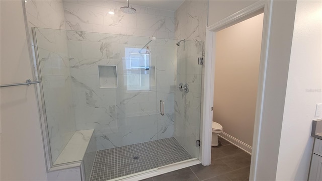 bathroom with tile patterned flooring, a shower with door, vanity, and toilet