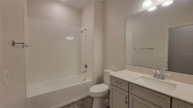 full bathroom with washtub / shower combination, hardwood / wood-style floors, vanity, and toilet