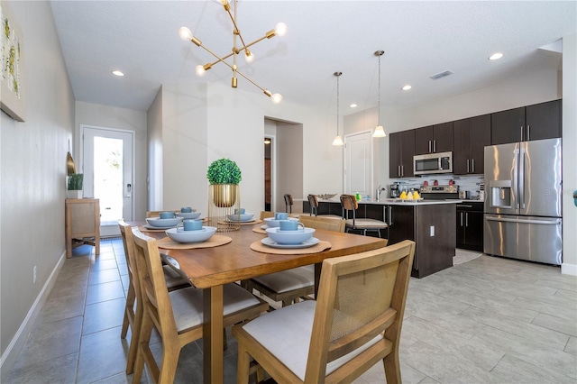 dining space with light tile patterned floors and a notable chandelier