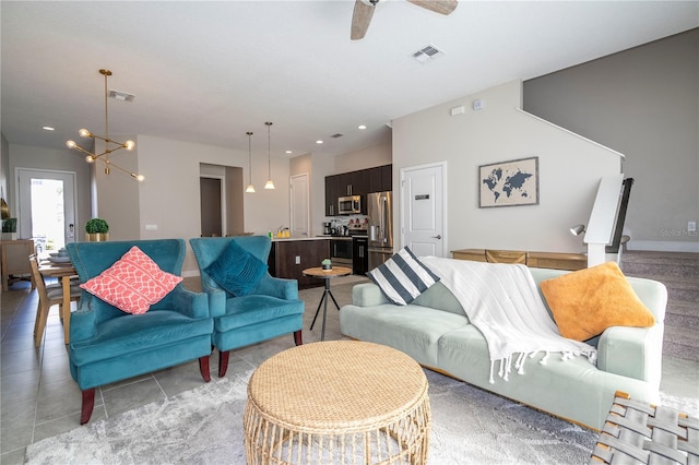 living room with light tile patterned floors and ceiling fan with notable chandelier