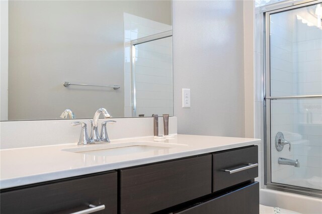 bathroom featuring vanity and bath / shower combo with glass door