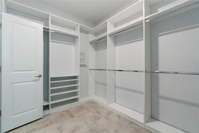 walk in closet with light tile patterned floors