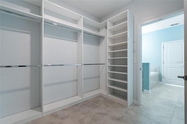 spacious closet with light tile patterned floors