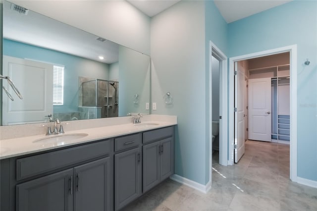 bathroom with toilet, vanity, and walk in shower