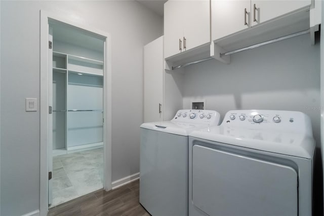 clothes washing area featuring cabinets, independent washer and dryer, and dark wood-type flooring