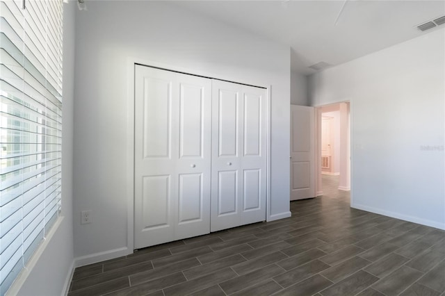 unfurnished bedroom with dark hardwood / wood-style flooring and a closet