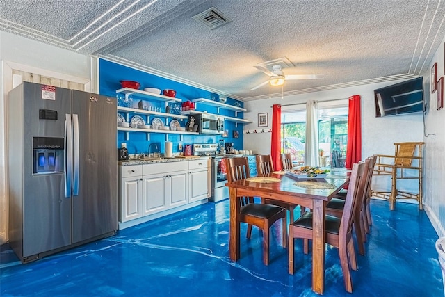 dining space with a textured ceiling, ceiling fan, ornamental molding, and sink