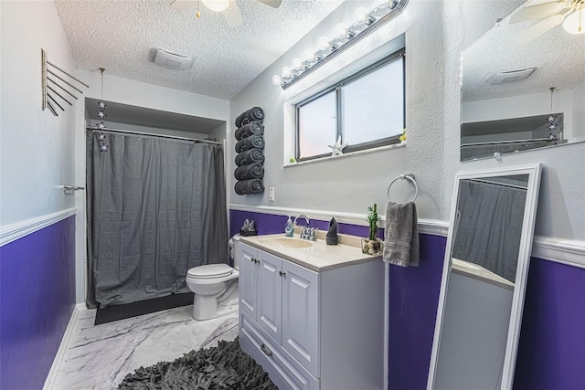 bathroom featuring vanity, ceiling fan, toilet, and a textured ceiling