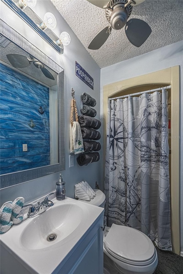 bathroom featuring vanity, ceiling fan, toilet, a textured ceiling, and walk in shower