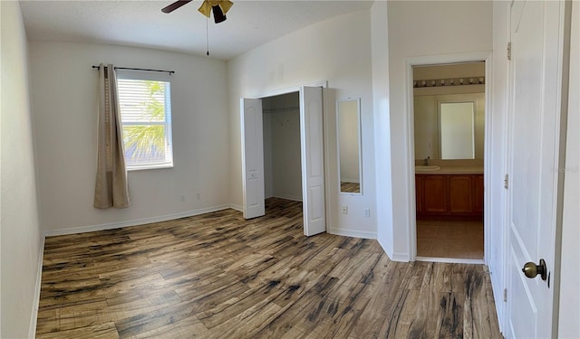 unfurnished bedroom with sink, ceiling fan, a textured ceiling, connected bathroom, and wood-type flooring