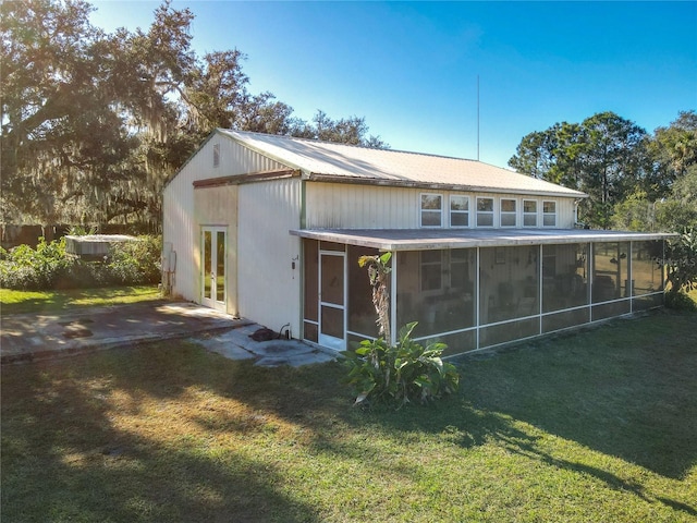 back of house featuring a sunroom and a yard