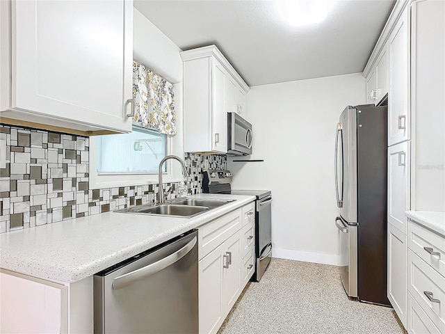 kitchen with tasteful backsplash, sink, white cabinets, and appliances with stainless steel finishes