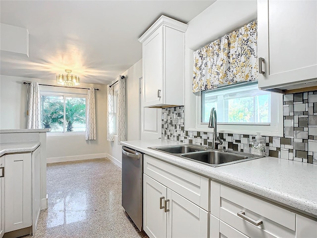 kitchen with light stone countertops, sink, stainless steel dishwasher, backsplash, and white cabinets