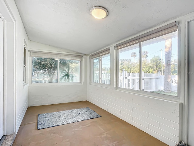 unfurnished sunroom featuring a wealth of natural light and vaulted ceiling