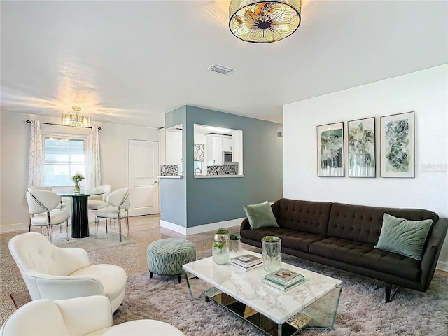 living room with carpet flooring and a notable chandelier