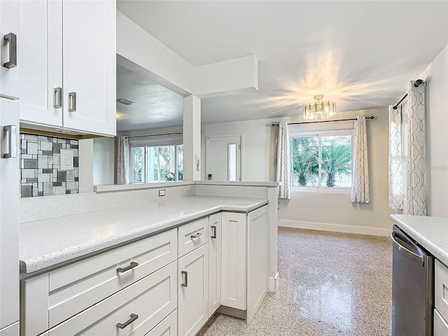 kitchen with decorative backsplash, a wealth of natural light, white cabinets, and stainless steel dishwasher