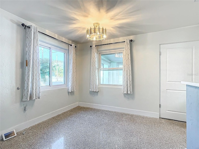 unfurnished room with an inviting chandelier