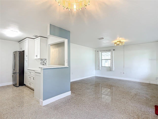 kitchen featuring white cabinetry and stainless steel refrigerator