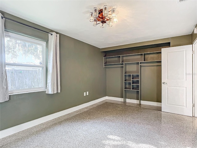 unfurnished bedroom featuring a closet and a chandelier