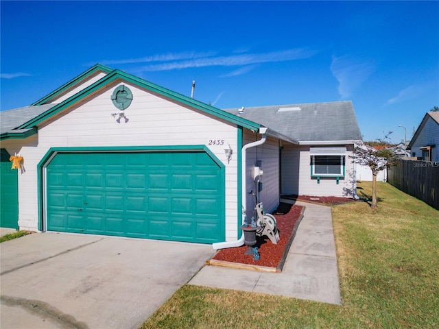 single story home featuring a garage and a front lawn