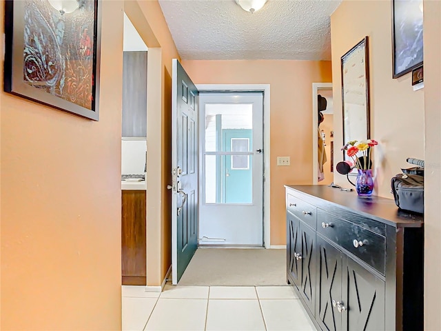 corridor with light tile patterned floors and a textured ceiling