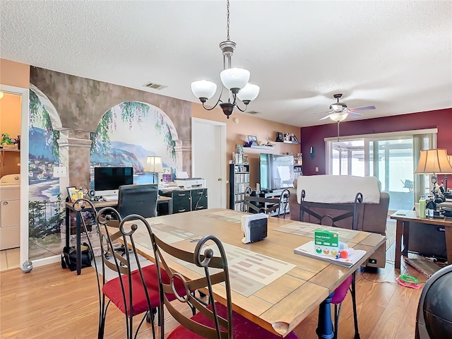 dining area with a textured ceiling, washer / dryer, ceiling fan with notable chandelier, and light wood-type flooring