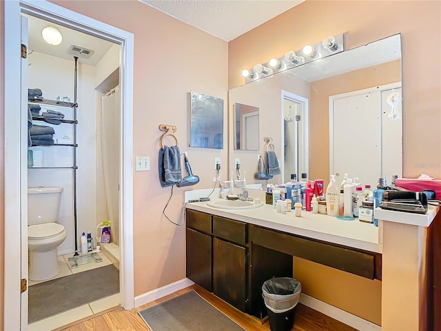 bathroom with vanity, hardwood / wood-style flooring, toilet, and walk in shower