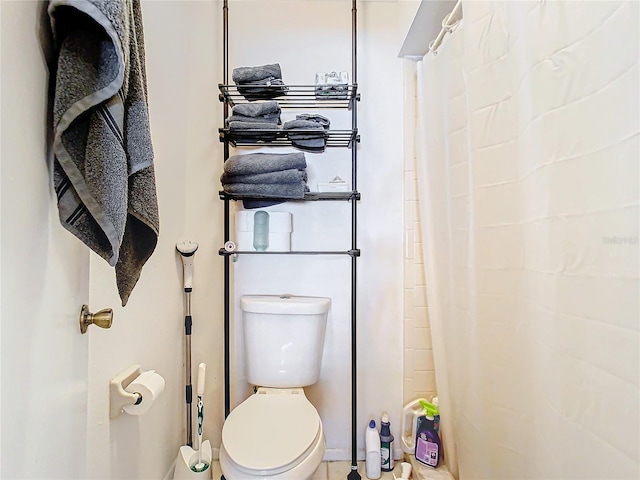 bathroom featuring a shower with shower curtain and toilet