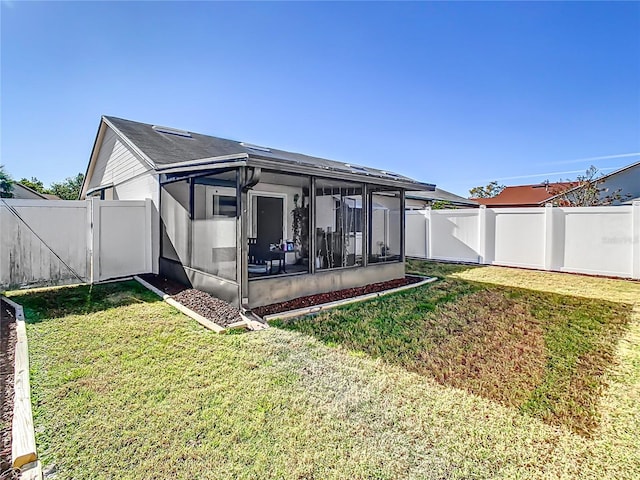 rear view of house with a yard and a sunroom