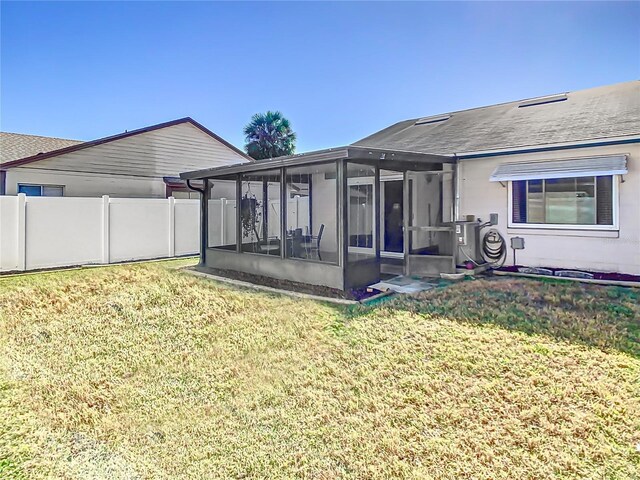 back of property featuring a yard and a sunroom