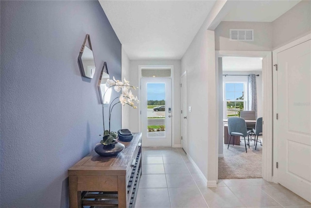 doorway to outside with light tile patterned floors