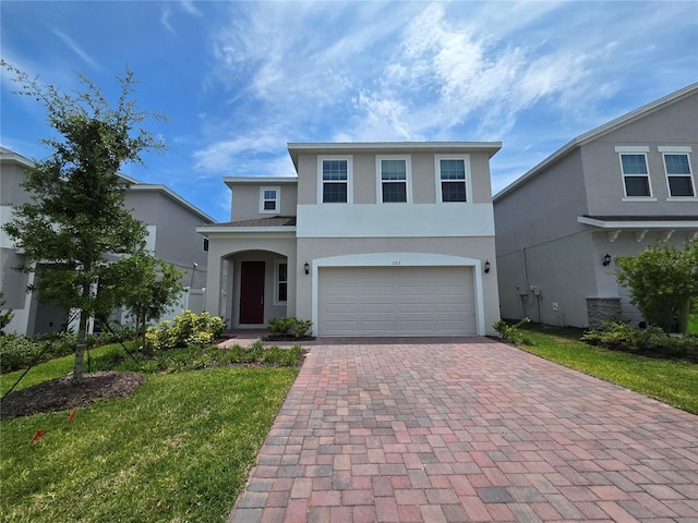 1162 Happy Forest Loop, Deland, FL 32720 - traditional-style home featuring stucco siding, decorative driveway, a garage, and a front lawn