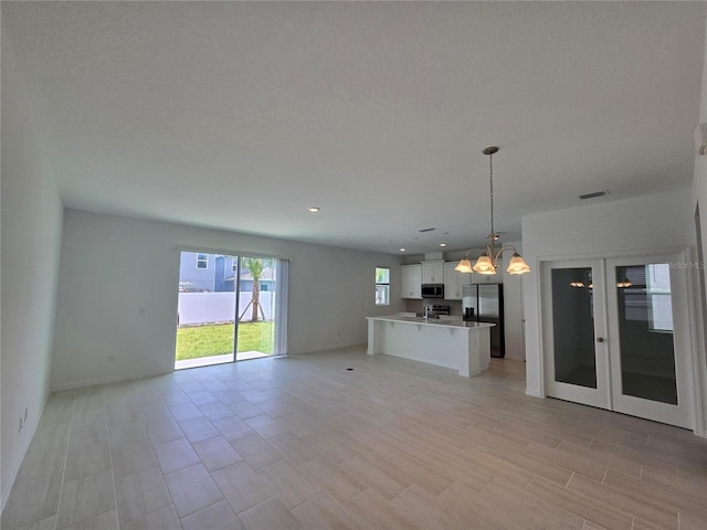 1162 Happy Forest Loop, Deland, FL 32720 - unfurnished living room featuring a chandelier, baseboards, and recessed lighting