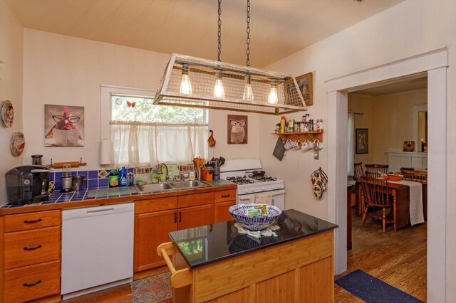 kitchen featuring hardwood / wood-style floors, pendant lighting, white appliances, sink, and tile counters