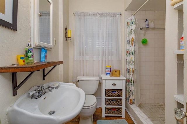 bathroom featuring toilet, sink, and walk in shower