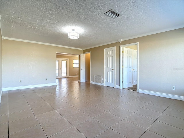 tiled empty room featuring a textured ceiling and ornamental molding