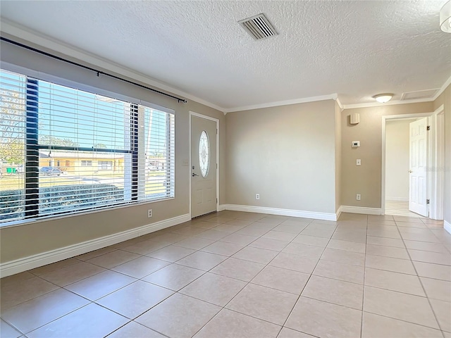 tiled spare room with a textured ceiling and crown molding